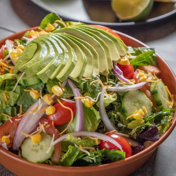 El Pollo Supremo's fresh Latin-American salad with avocado, corn, tomatoes, cucumbers, and red onion.